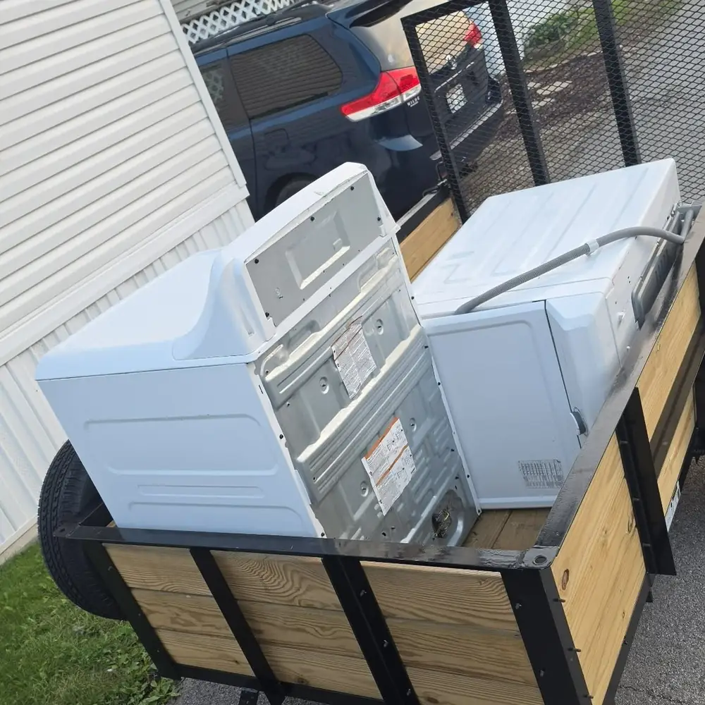 old washer and dryer loaded in a junk removal trailer