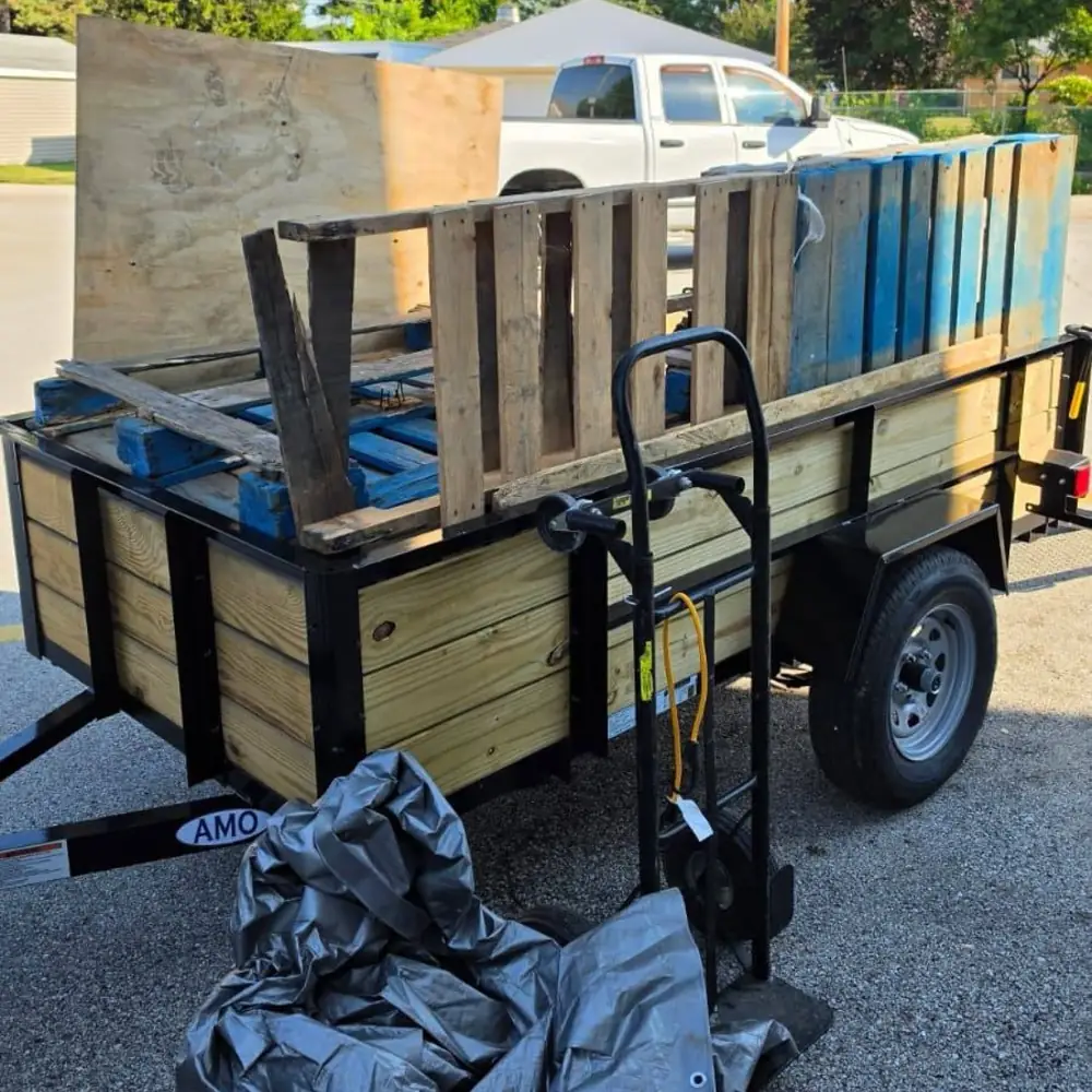 wooden pallets and furniture loaded on a utility trailer