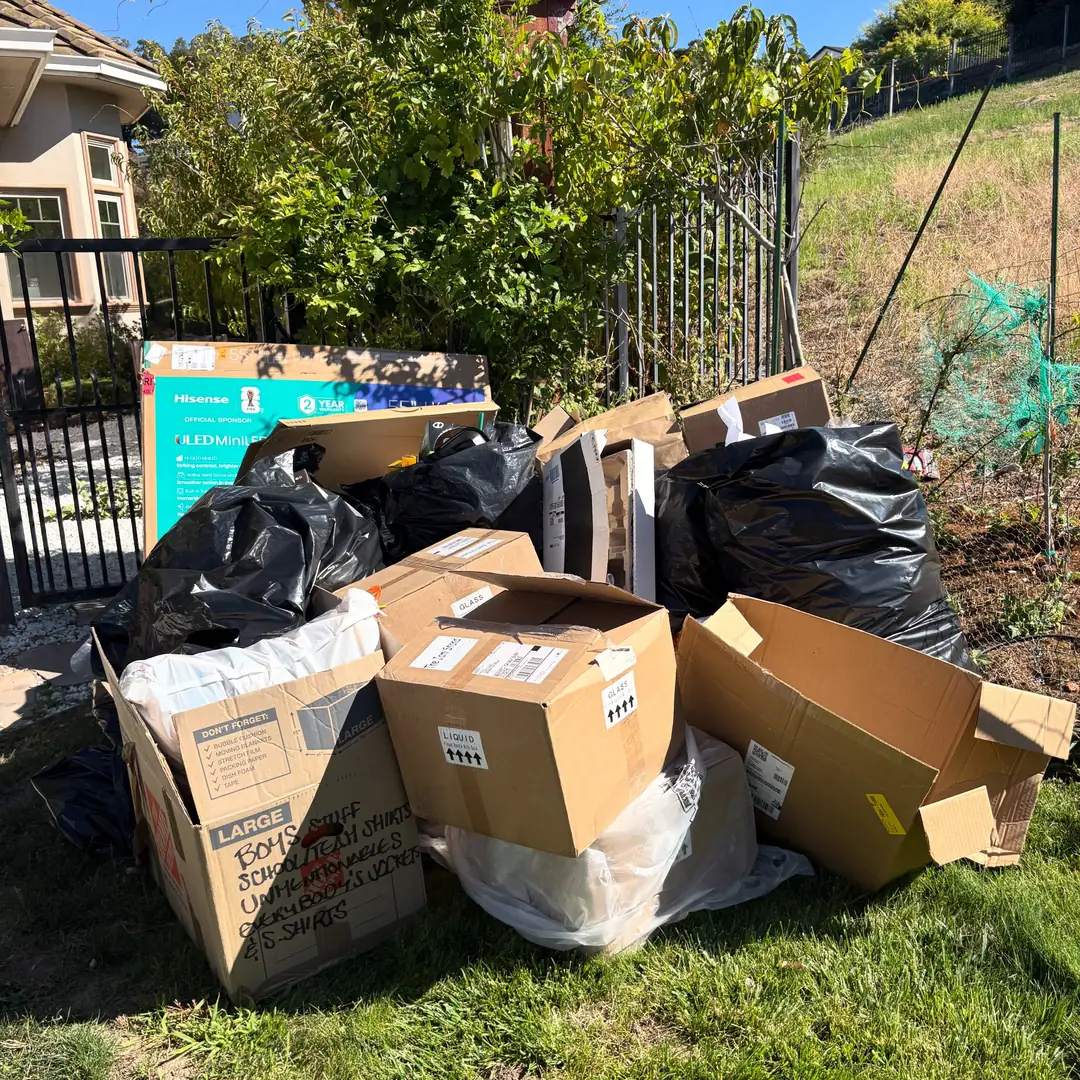 pile of boxes and yard debris on lawn before removal in Riverview
